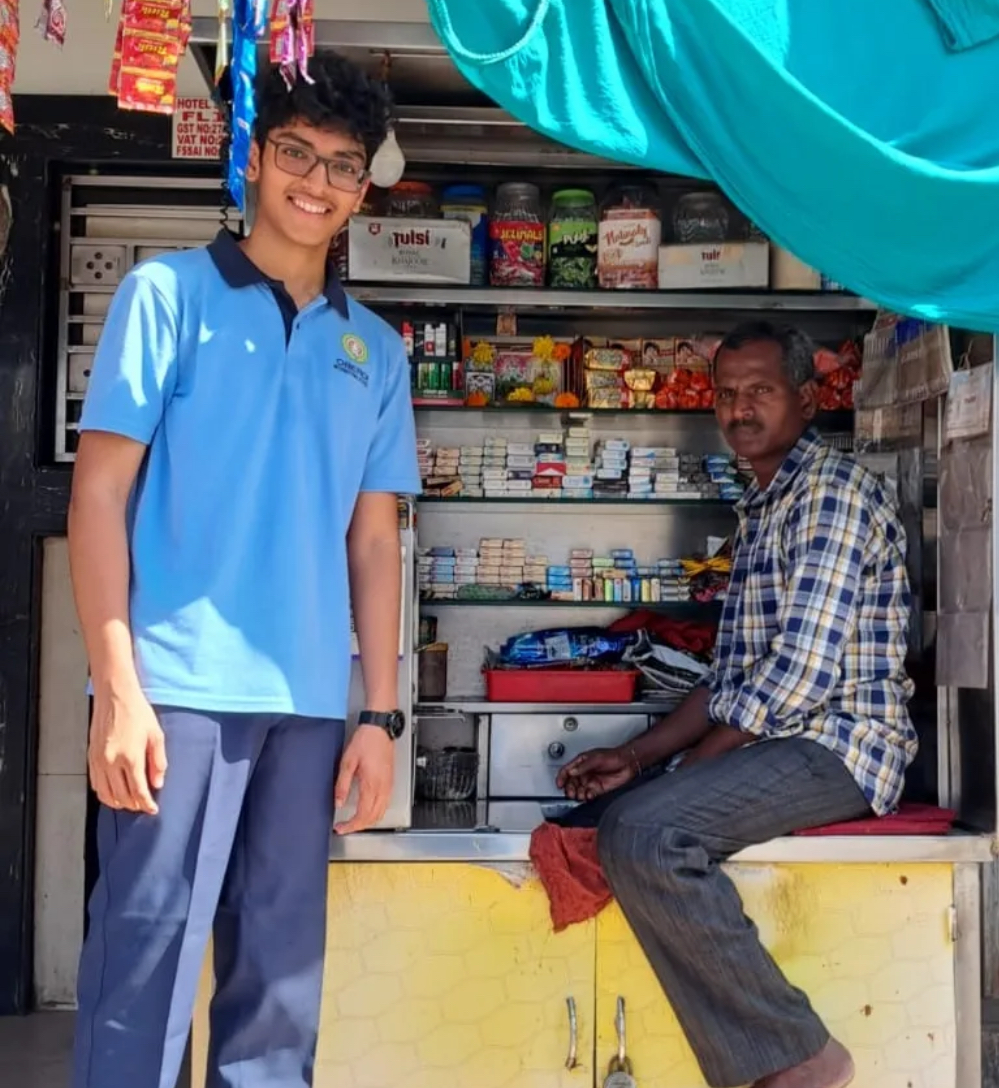 Standing with the owner of a neighbourhood general store